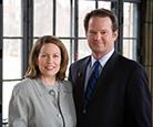 Craig and Ann Stinson posing together for a photo in front of a window.